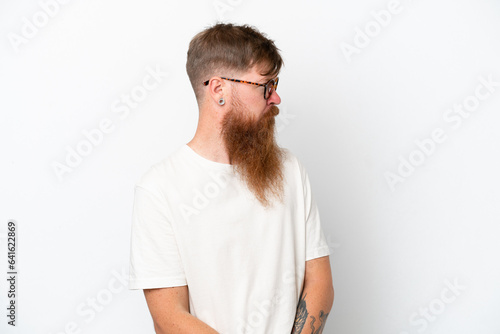 Redhead man with long beard isolated on white background keeping the arms crossed © luismolinero