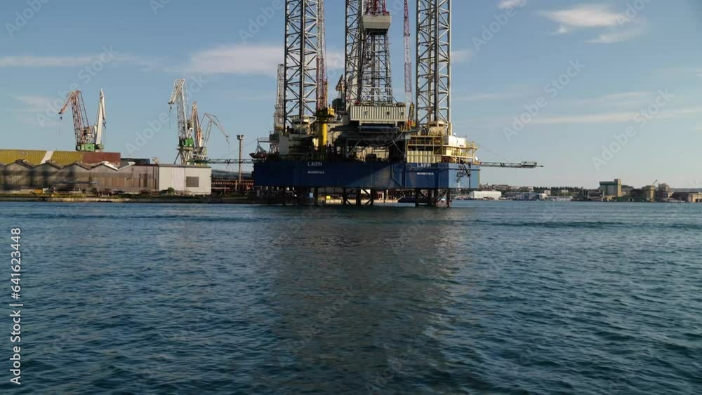Boat, passengers and crew passing the oil platform at shipyard Uljanik in Pula Boat, passengers and crew passing the oil platform at shipyard Uljanik in Pula