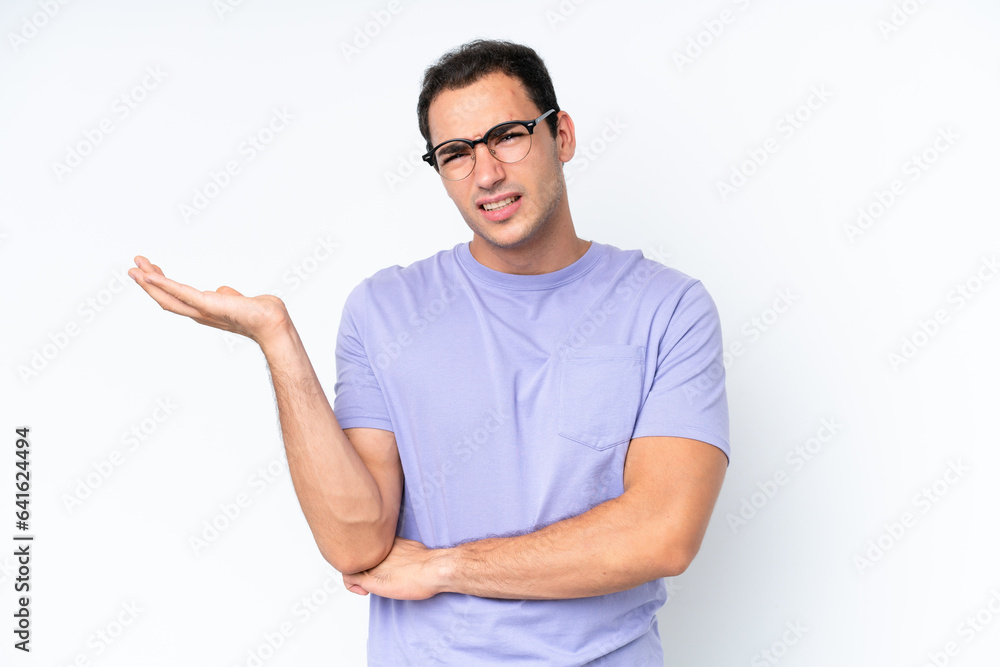 Young caucasian man isolated on white background having doubts