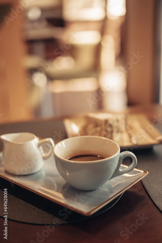 A cup of aromatic coffee in a white cup in a cafe on a table