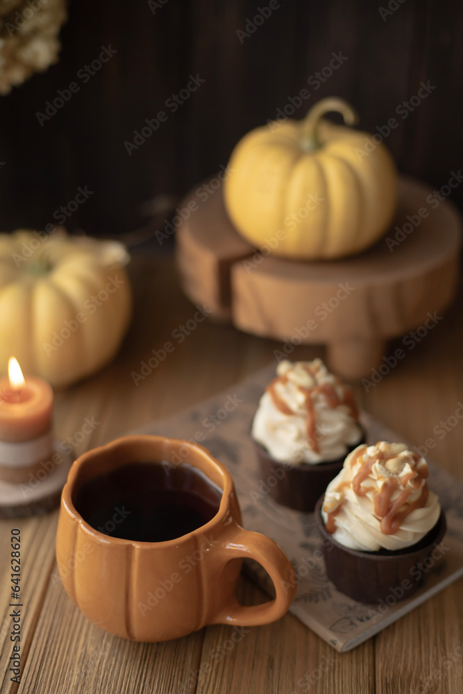 A cozy still life with a cup in the form of a pumpkin, a candle and small pumpkins A cozy still life with a cup in the form of a pumpkin, a candle and small pumpkins