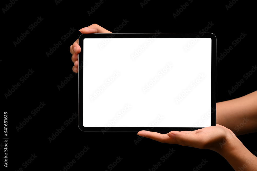 Hands holding digital tablet on black background. Blank screen for your advertising text or promotional content Hands holding digital tablet on black background. Blank screen for your advertising text or promotional content