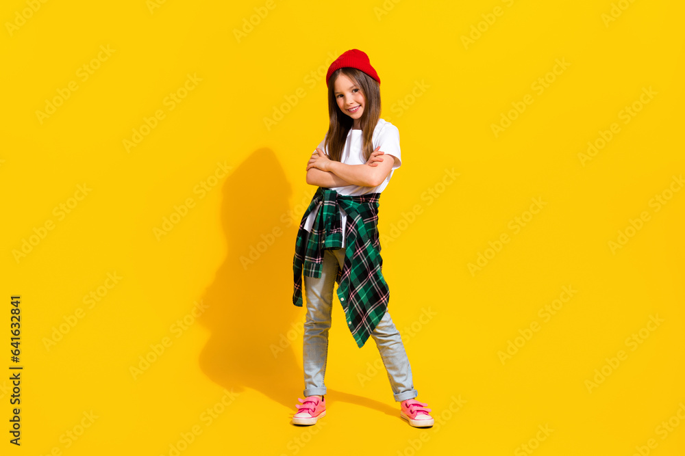 Full size photo of adorable schoolgirl crossed hands cool pose dressed stylish white outfit isolated on yellow color background