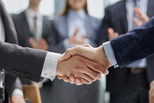 businessman and businesswoman shaking hands in hallway.