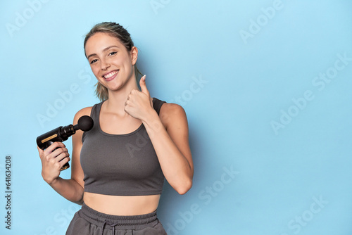 Canvas Print Athlete holding an electric massager smiling and raising thumb up