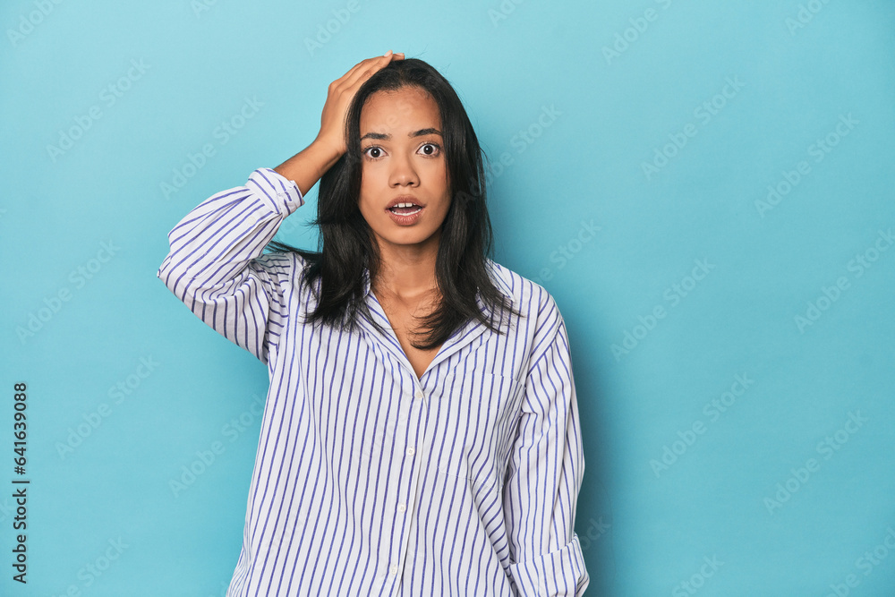 Fototapeta premium Filipina young woman on blue studio being shocked, she has remembered important meeting.