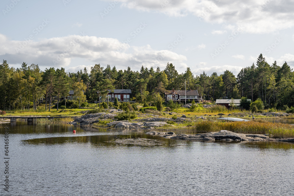 Naklejka premium schwedische Häuser im Wald an der Schwedischen Küste auf einer Insel, idyllisches Wohnen in der Natur