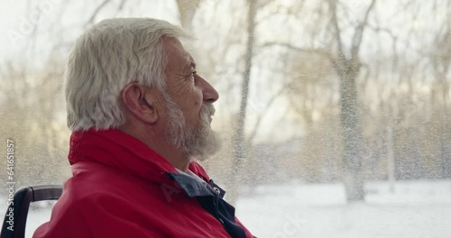 Side view of old male sitting on bus driving. Passenger with grey hair and beard, lloking forward though window, thinking, recollecting. Concept of urban settings and life. photo