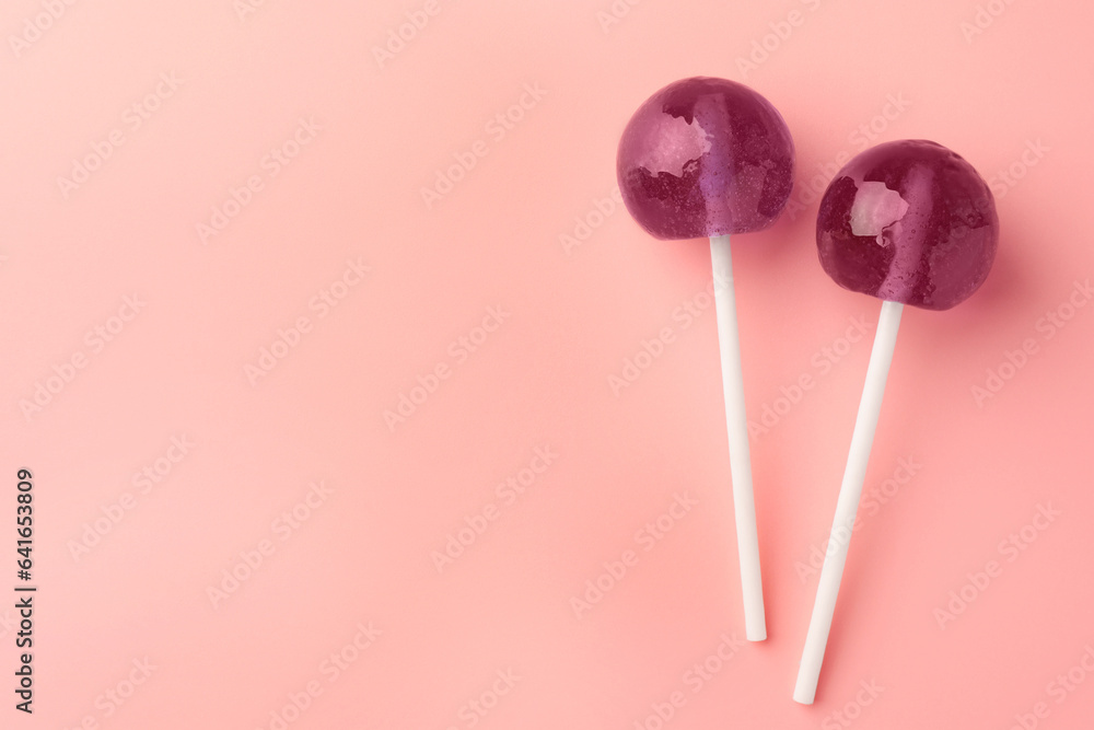 Tasty lollipops on pink background, flat lay. Space for text Tasty lollipops on pink background, flat lay. Space for text