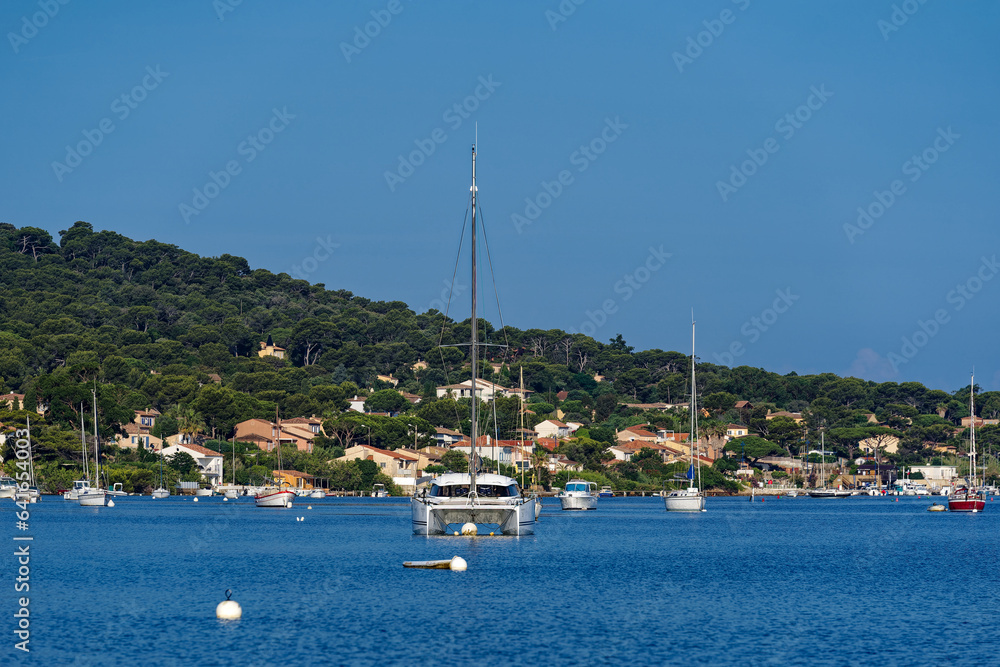 Moored motor boats and sailing boats at bay of Giens Peninsula on a sunny late spring morning. Photo taken June 8th, 2023, Giens, Hyères, France.