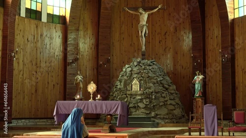 Nun is praying in the Parroquia San Jose church, San Martin de los Andes, Neuquen, Argentina photo