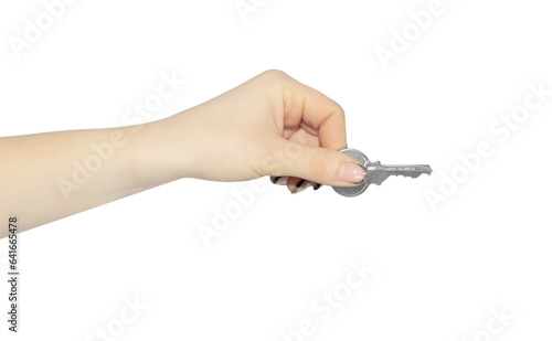 A woman's hand holds a key in her hand, isolated from the background. The concept of security, house trade.