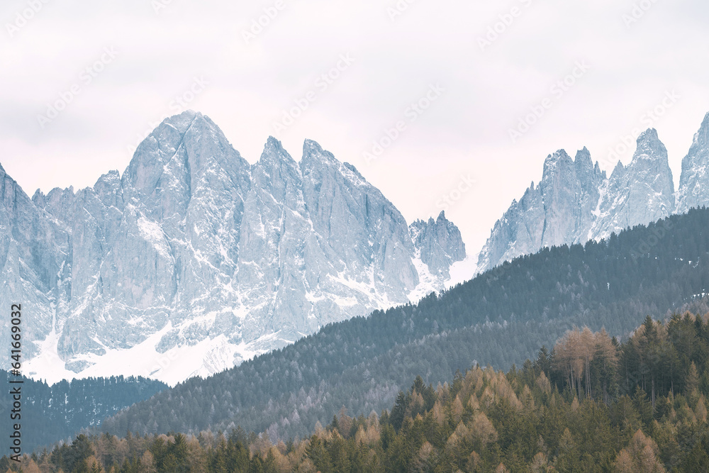 Majestic Dolomites Landscape. Snow-Covered Mountains and Pine Trees in the Italian Alps. A snow covered mountain with pine trees in the foreground.