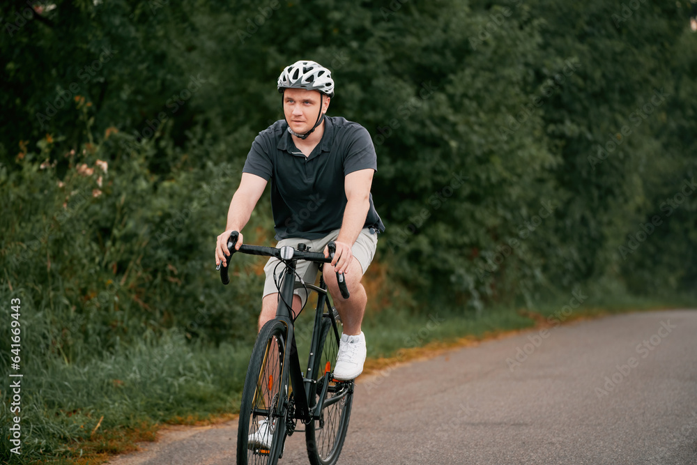 Obraz premium Young Male Cyclist Embracing an Active Lifestyle. A front-view image of a cyclist riding his gravel bike in the countryside