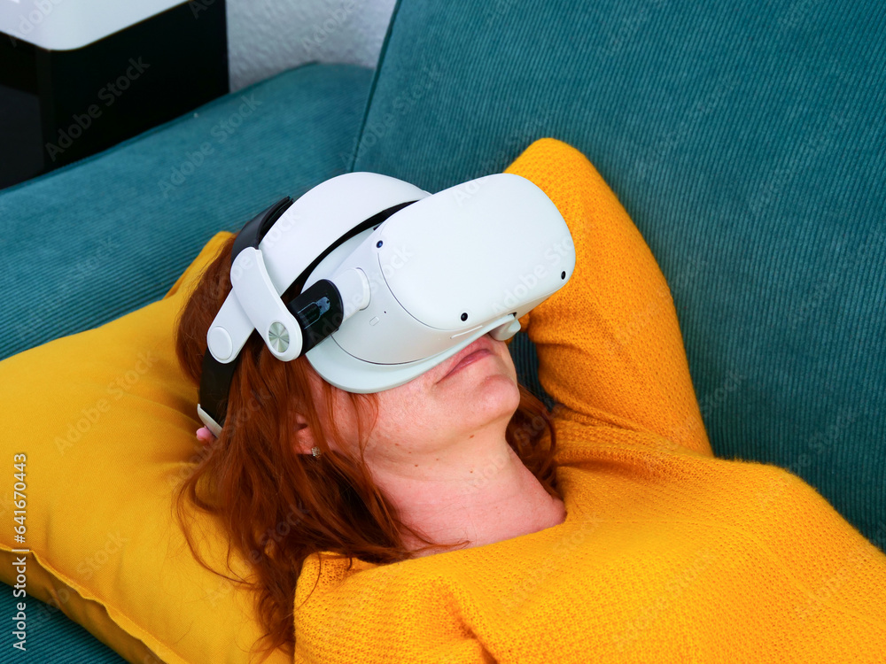 The man relaxing and playing VR goggles and using futuristic tablet at home. the concept of metaverse, versual reality, future, technology, and internet of things.