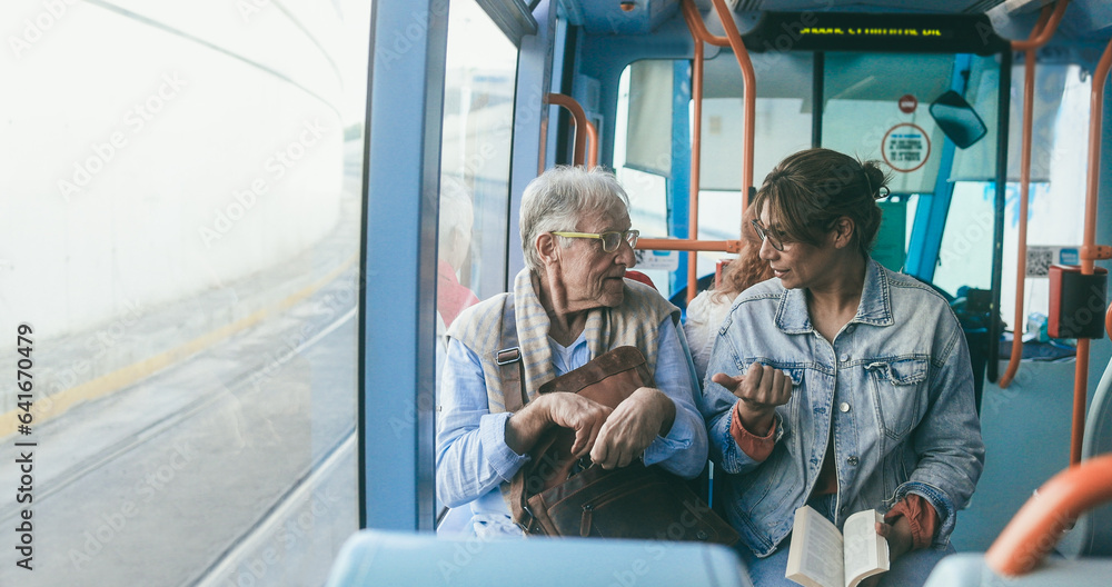 Senior man and mature woman talking together while traveling with tram transportation - Soft focus on man face