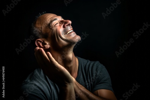 Lifestyle portrait photography of a joyful mature man putting the hand on the forehead to look for someone in the distance against a matte black background. With generative AI technology
