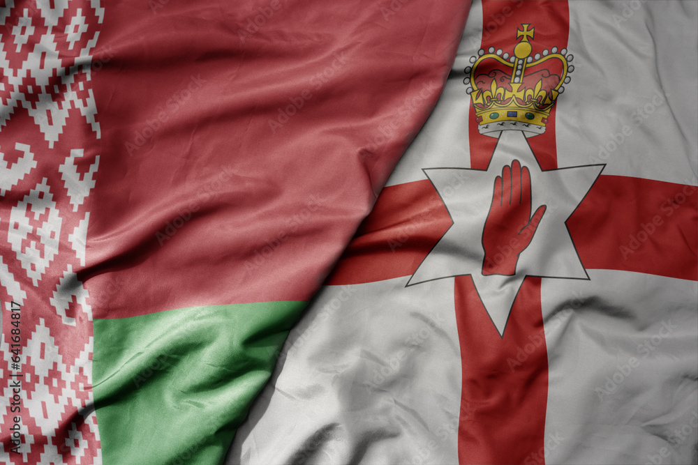 big waving national colorful flag of belarus and national flag of northern ireland .