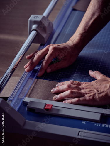 Photography Unrecognizable man working on bookbinding machine at workshop