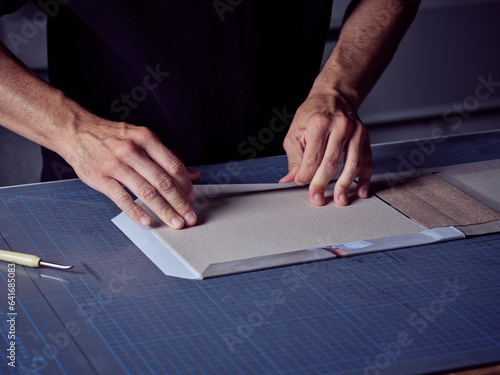 Crop bookbinder making book at workbench