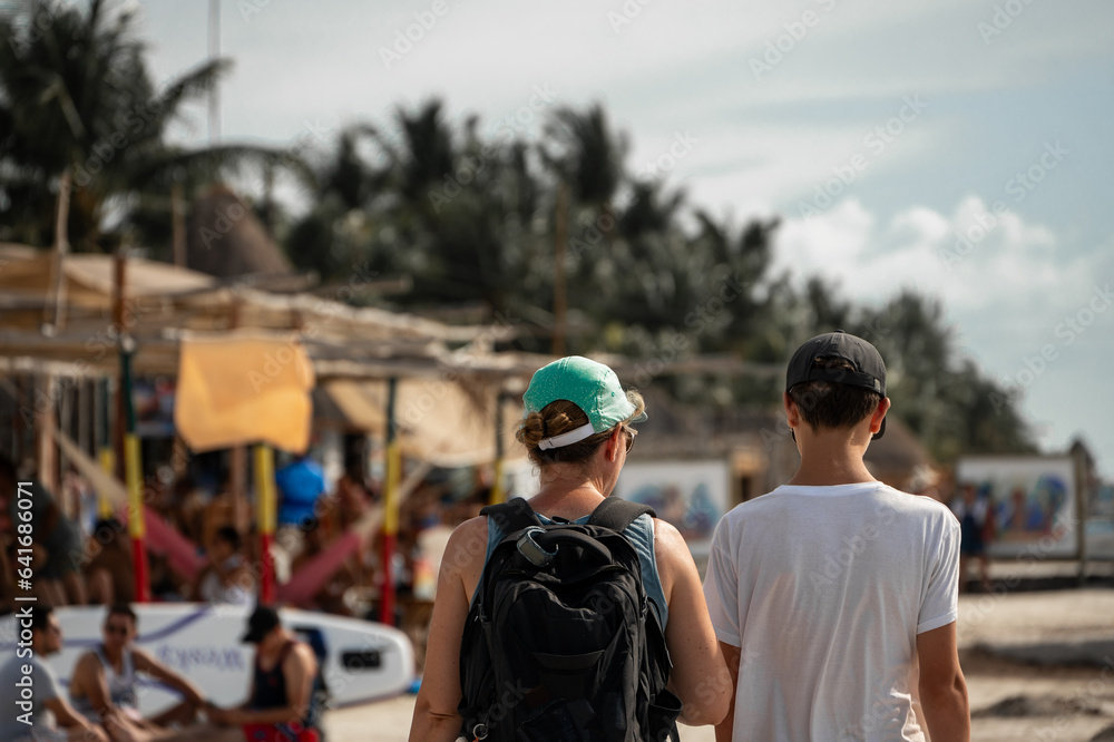 mother and son are walking in the streets of isla holbox, mexico mother and son are walking in the streets of isla holbox, mexico