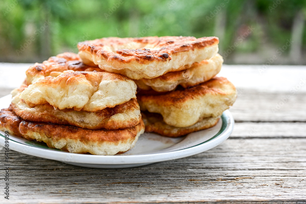 Traditional Bulgarian home made deep fried patties covered with sugar оn rustic backgroud.Mekitsa or Mekica, on wooden rustic background. Made of kneaded dough that is deep fried Traditional Bulgarian home made deep fried patties covered with sugar оn rustic backgroud.Mekitsa or Mekica, on wooden rustic background. Made of kneaded dough that is deep fried