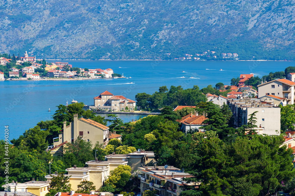 Obraz premium view of the old town of Kotor in Montenegro and the coast of the Bay of Kotor, the sea and medieval European architecture, city streets, red tiled roofs, the concept of traveling across the Balkans
