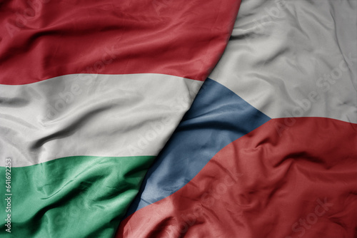 big waving national colorful flag of hungary and national flag of czech republic .
