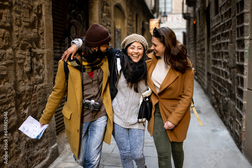 Vászonkép Cheerful multi-ethinc group of friends tourists having fun and walking on the st