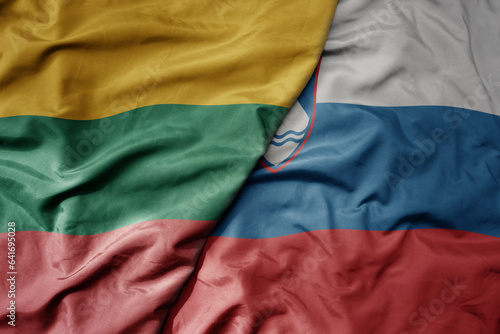 big waving national colorful flag of lithuania and national flag of slovenia .