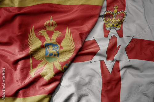 big waving national colorful flag of montenegro and national flag of northern ireland .