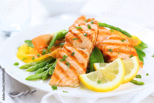 Exquisite Grilled Salmon Fillet Served with Fresh Asparagus Spears and Lemon Wedges on a White Plate: A Gourmet Culinary Experience Ideal for Fine Dining and Healthy Lifestyle