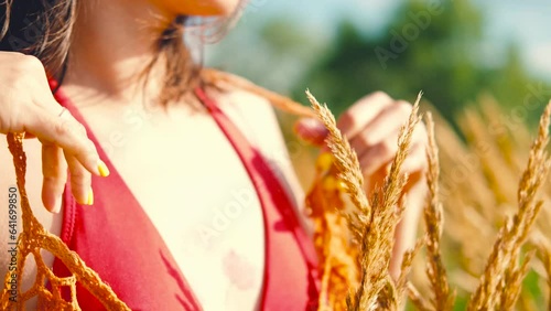 Happy free asian woman walking in tall grass on a sunny summer day. Portrait of a hippie woman in a bright orange boho style top photo