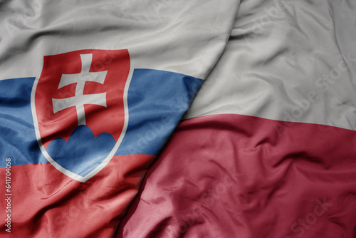 big waving national colorful flag of slovakia and national flag of poland .