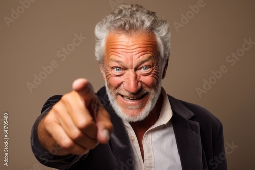 Close-up portrait photography of a grinning mature man making a i see you gesture pointing at one's eyes against a beige background. With generative AI technology © Markus Schröder
