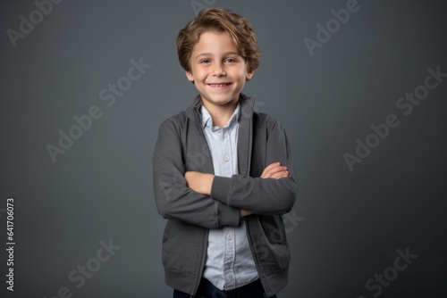Lifestyle portrait photography of a grinning kid male putting hands on hips against a cool gray background. With generative AI technology