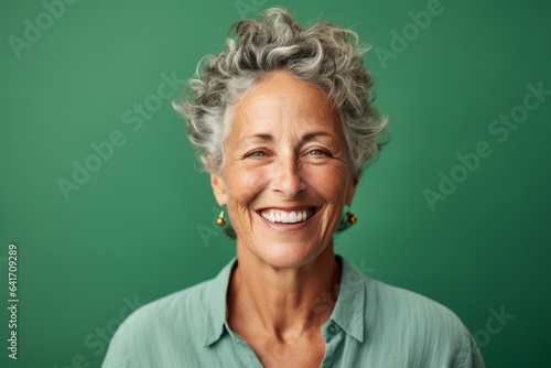 Headshot portrait photography of a happy mature woman winking against a spearmint green background. With generative AI technology