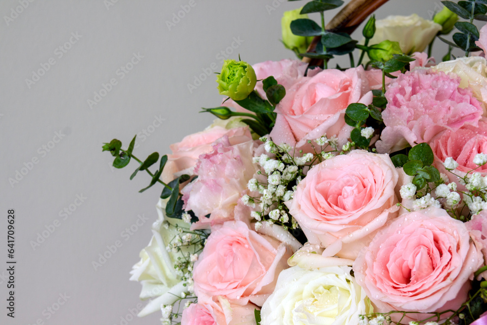 Flowers composition. Pink rose flowers in basket on pastel beige background. Copy space for text.
