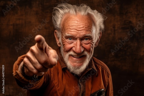 Close-up portrait photography of a grinning old man pointing down against a copper brown background. With generative AI technology