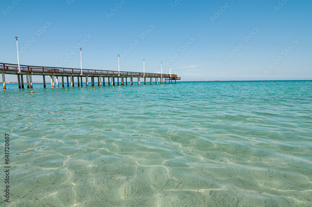 Pier in the sea on a beautiful beach with crystalline water on a summer morning, seascape of La Paz baja california Sur Mexico. Playa El Coromuel.