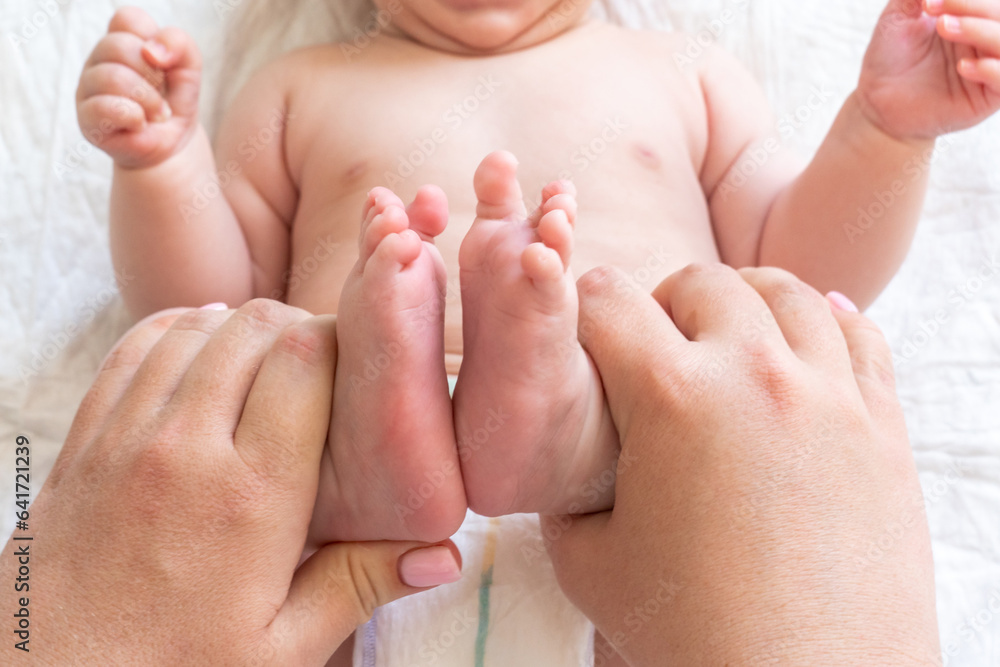 Massage time for newborn's tiny feet, Concept of a mother's healing touch Massage time for newborn's tiny feet, Concept of a mother's healing touch