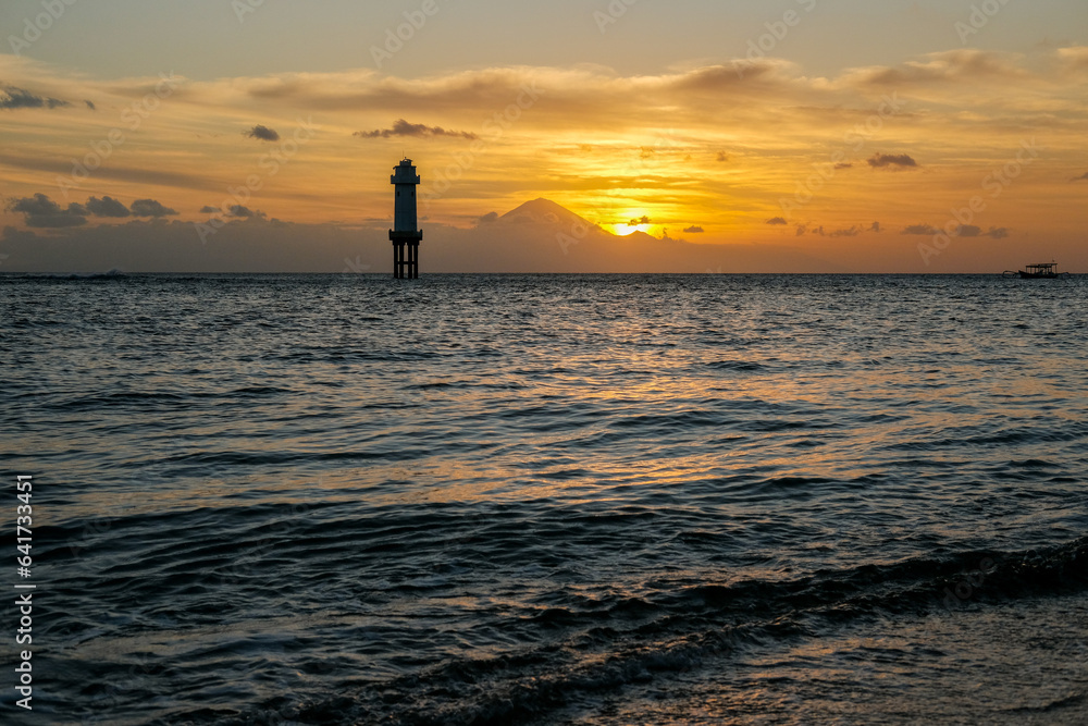 sunset view on senggigi lombok beach with the silhouette of mount agung bali, sunset over the sea, sunset at the beach, sunset and mountain, lighthouse at sea
