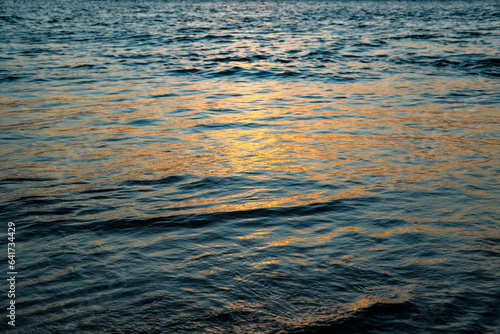 sea ​​water with the glow of the setting sun, the color of the sea at sunset, sunset sea water, sunset on the beach, sunset over the sea, waves on the beach, small waves of the sea, orange sea water