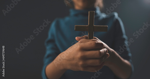 A little girl is using a cross to protect herself and holding a cross.