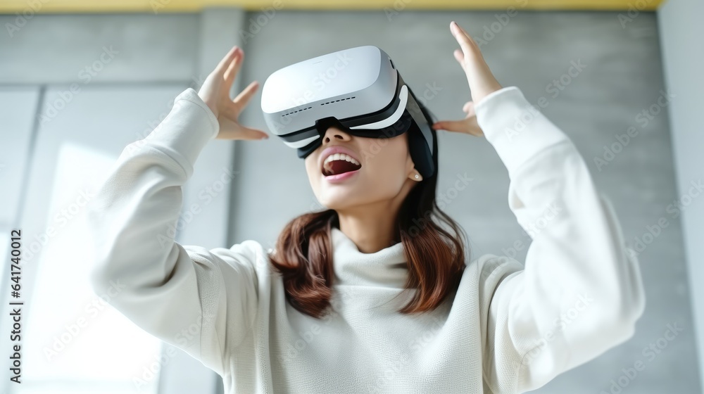 Naklejka premium Young woman sitting at desk and wearing a VR headset, Experiencing virtual reality, Interacting with virtual reality.