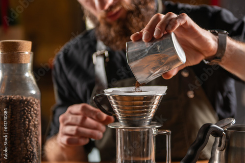 Fotobehang Skilled barista using the Kalita Wave dripper coffee maker to create a meticulou