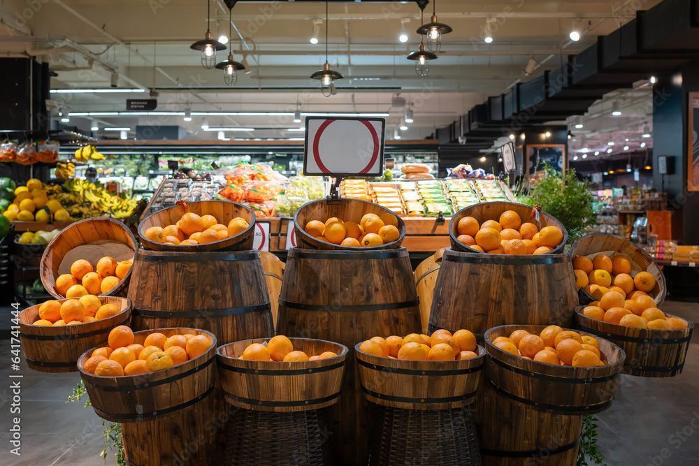 Fresh orange placing in wood barrel display in grocery store. Fresh orange arrange neatly in super market.