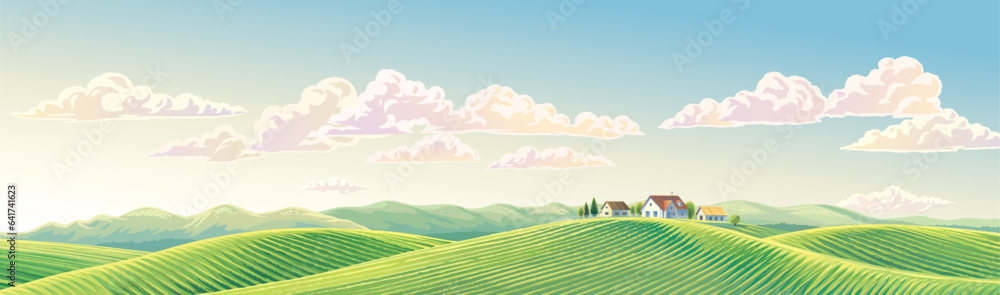 Summer rural landscape panoramic format, with hills and agriculture fields and village, on top of a hill.