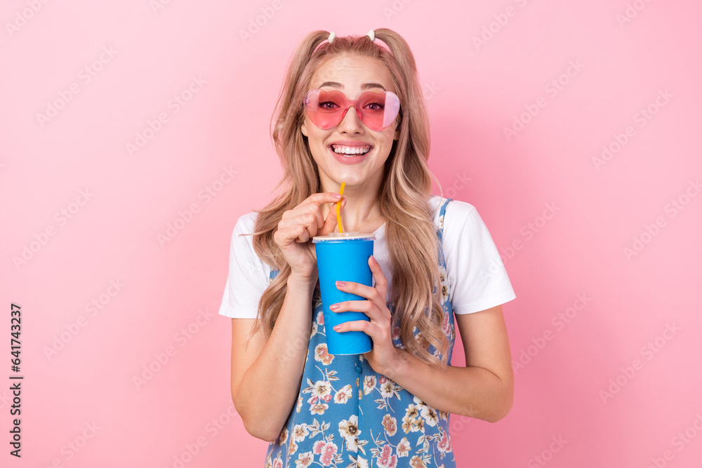 Portrait of toothy beaming imrpressed girl with tails wear t-shirt under dress in sunglass drink soda isolated on pink color background Portrait of toothy beaming imrpressed girl with tails wear t-shirt under dress in sunglass drink soda isolated on pink color background