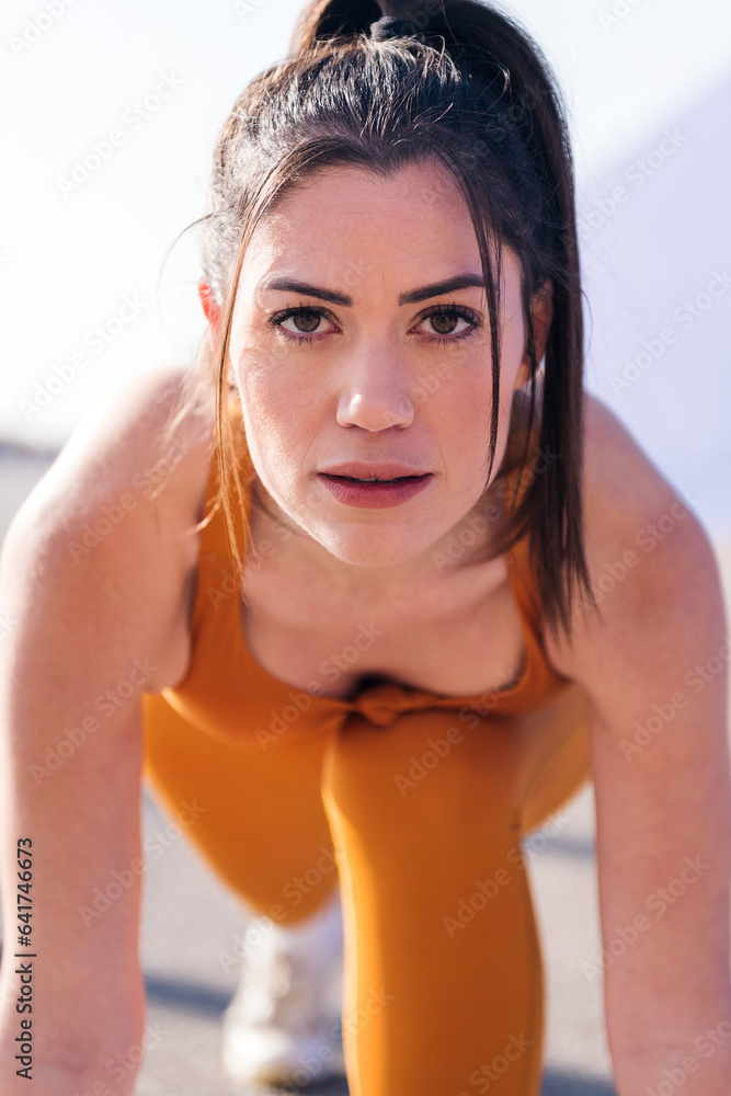 vertical close up portrait of a caucasian sporty woman ready to start a race, concept of sport and active lifestyle vertical close up portrait of a caucasian sporty woman ready to start a race, concept of sport and active lifestyle